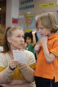 student with teacher in library